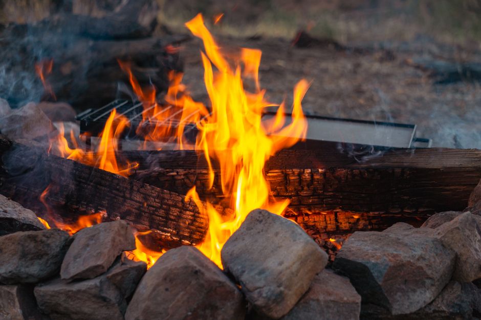 Cozy campfire with stones and wood, perfect for outdoor adventures and rustic living.
